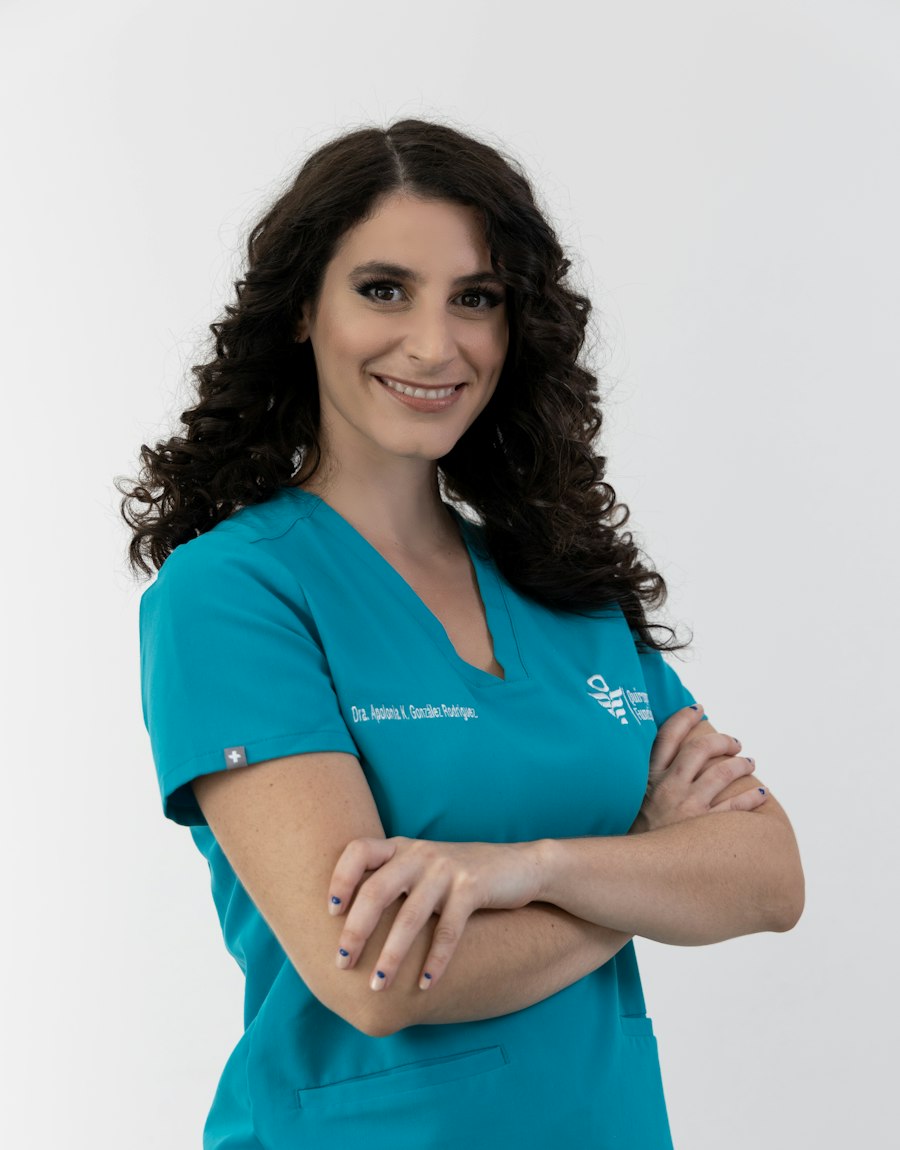 Odontóloga de DentalNova con bata blanca y estetoscopio, sonriendo con los brazos cruzados