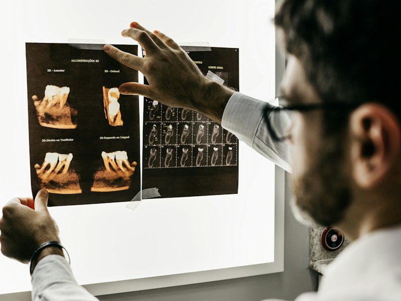 Odontólogo revisando radiografías dentales en pantalla